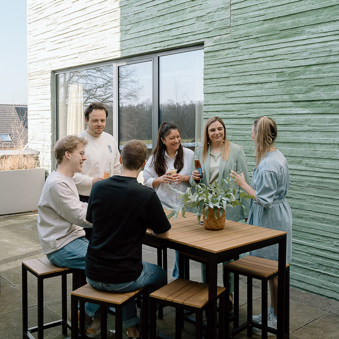 Een groep mensen die genieten van een drankje op het terras van onze workspace